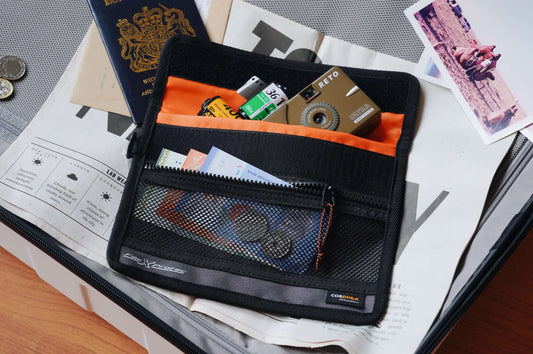 RETO Film X-Protec Bag (Medium) holding film rolls, coins and documents inside a travel suitcase.