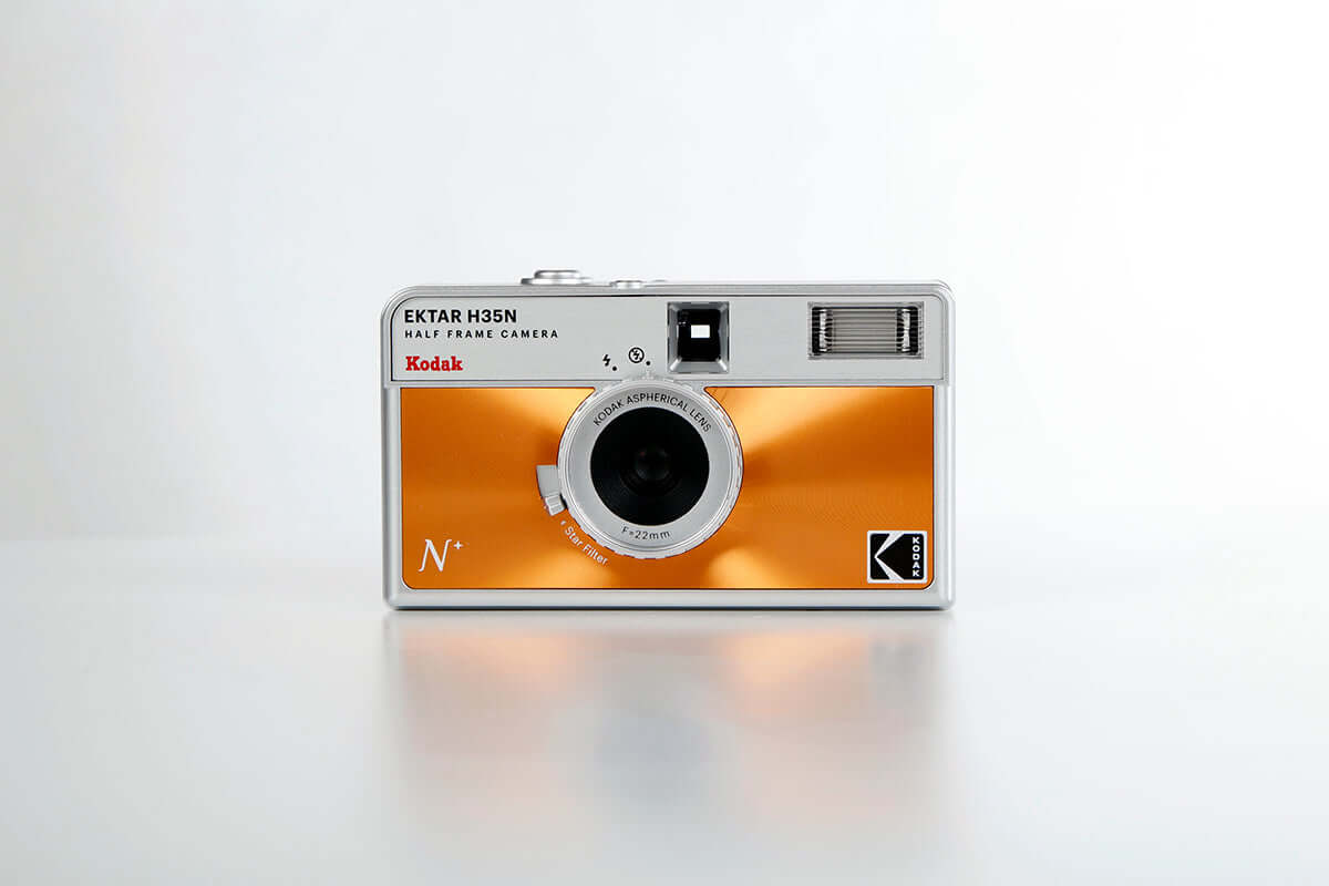 Kodak Ektar H35N Half Frame Film Camera (Orange) front view showcasing its sleek design and vibrant metallic orange color.