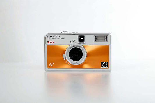 Kodak Ektar H35N Half Frame Film Camera (Orange) front view showcasing its sleek design and vibrant metallic orange color.
