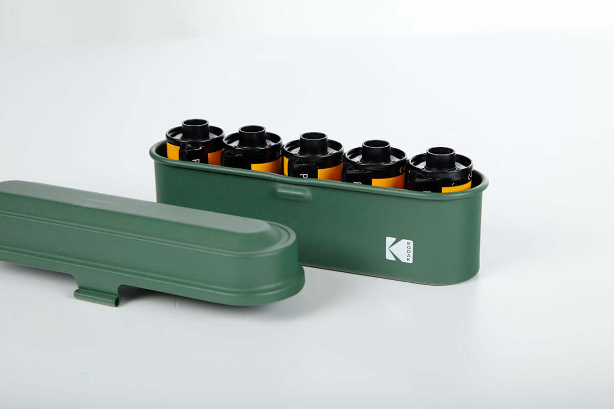 Open view of a Kodak 135 film case in the color green.