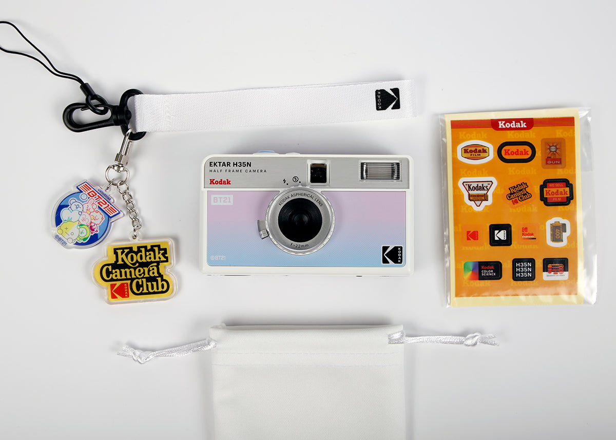 Kodak Ektar H35N BT21 edition half frame camera that includes wrist strap with keychains, traveling case, and a pack of stickers.