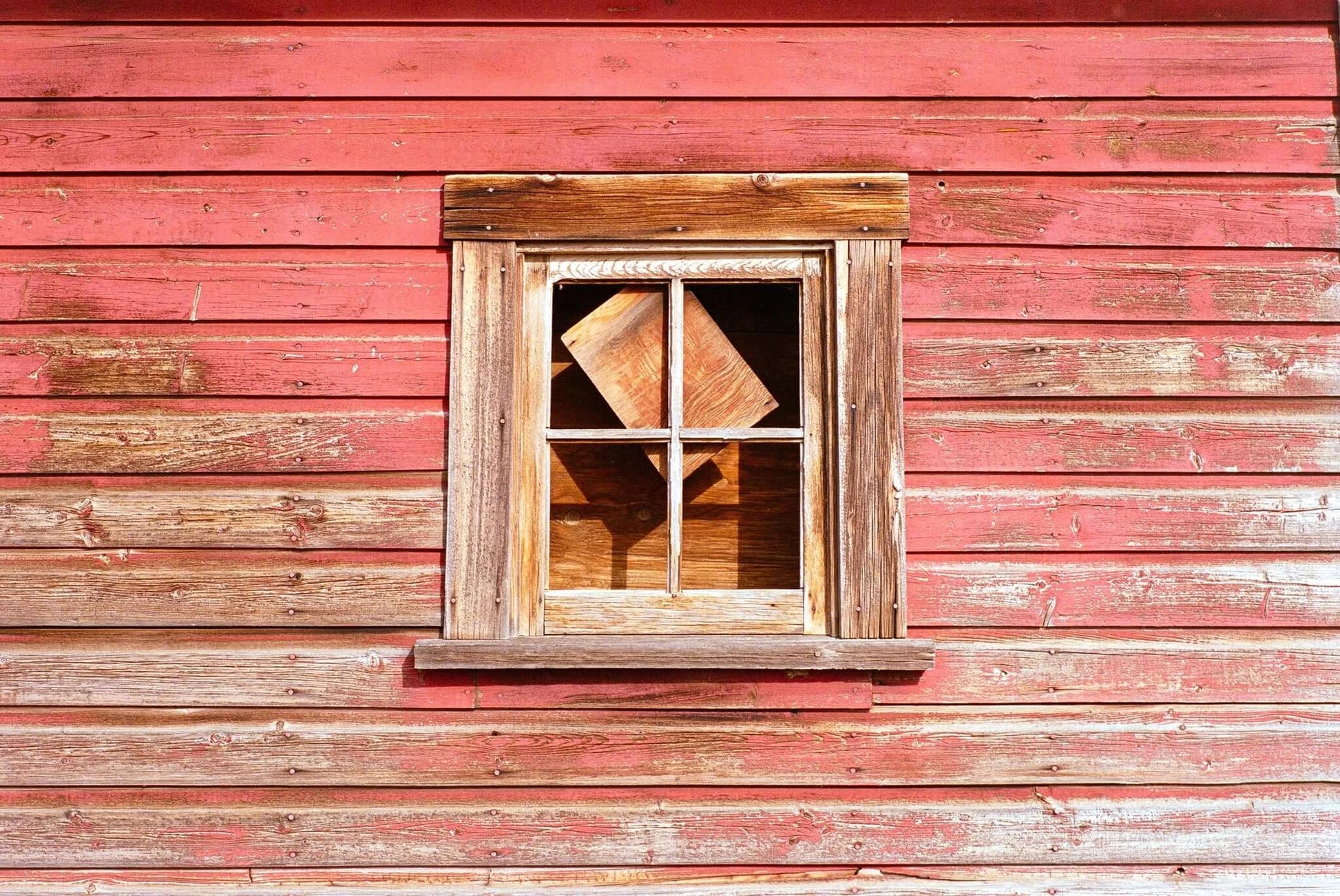 Street Candy Street Savvy Sample Image: Rustic window on a weathered red barn wall with wooden frame and interior wooden box.