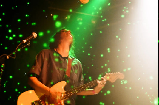 Musician performing with Revolog Volvox 200 Color Negative Film (35mm, 36 Exposures) showing vibrant green dots.