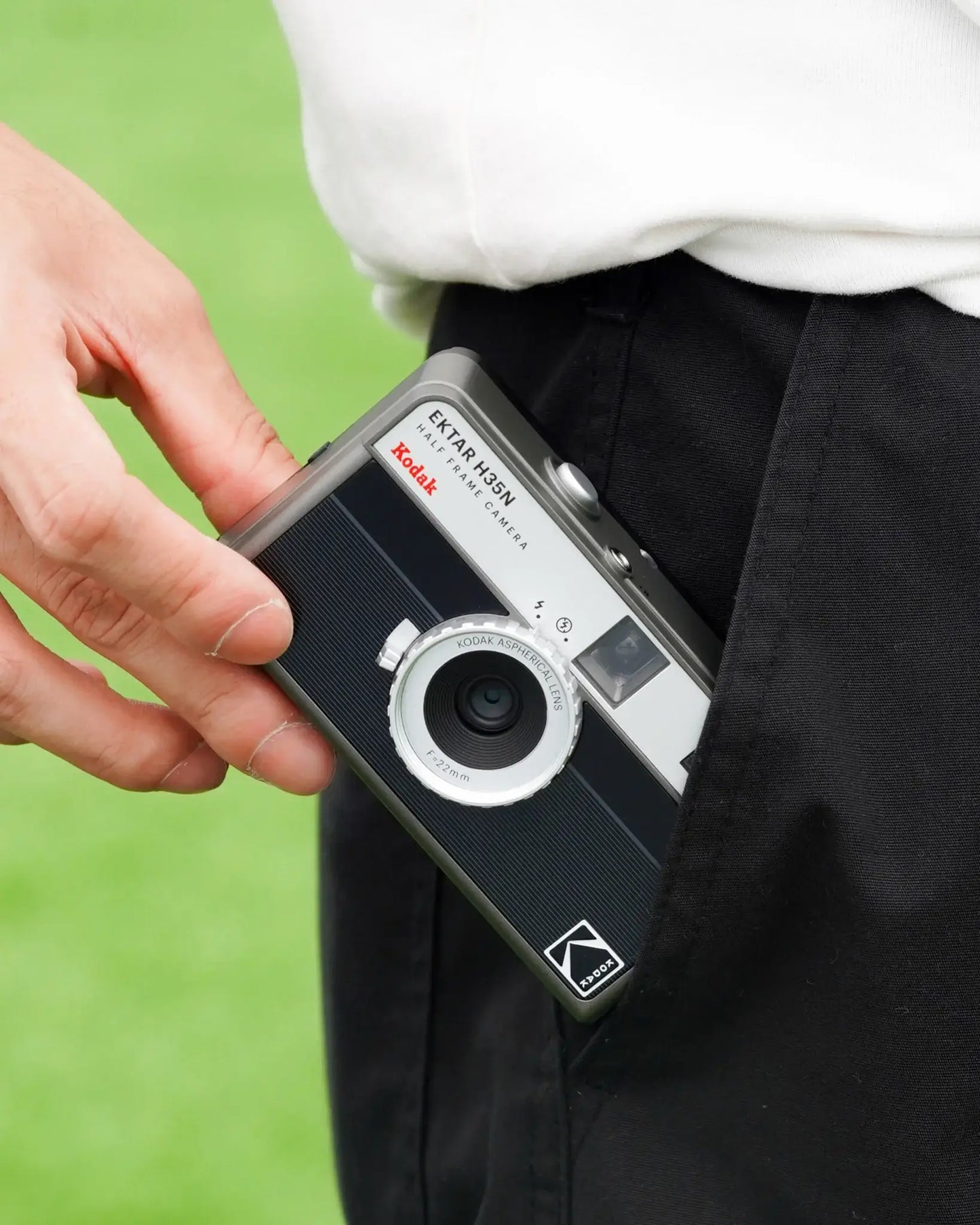 Kodak Ektar H35N Half Frame Film Camera (Striped Black) being placed in a pocket.