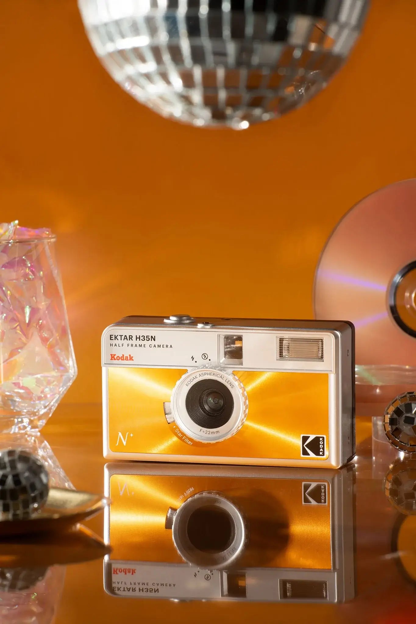 Kodak Ektar H35N Half Frame Film Camera (Orange) with stylish background elements reflecting creative photography.