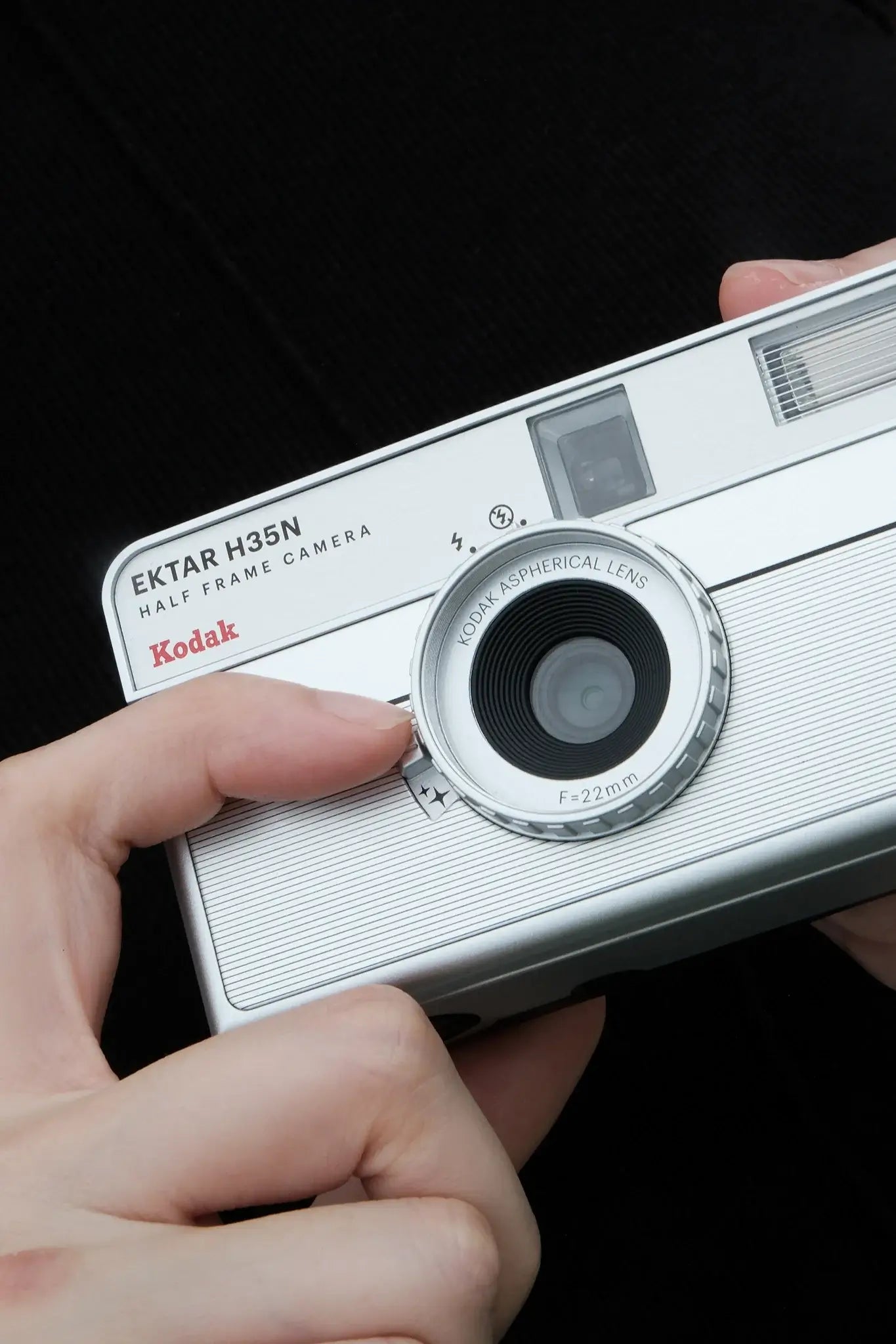 Kodak Ektar H35N Half Frame Film Camera (Striped Silver) being held in hand, showcasing compact design and lens.