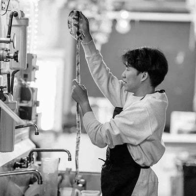 Person demonstrating film developing time techniques in a photography lab.
