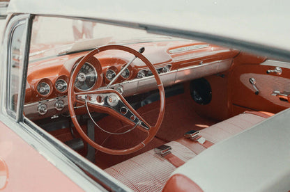 Vintage car interior featuring retro red dashboard and steering wheel, shot on Street Candy Psychedelic Street 400.