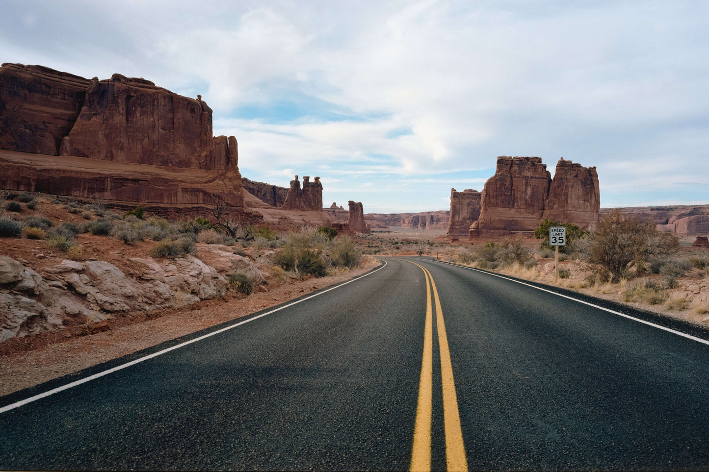 Scenic view of a winding road surrounded by stunning rock formations in a desert landscape.