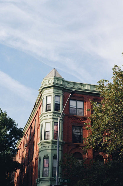 Historic brick building corner captured with Kodak Kodacolor 200 film, showcasing architectural details and greenery.