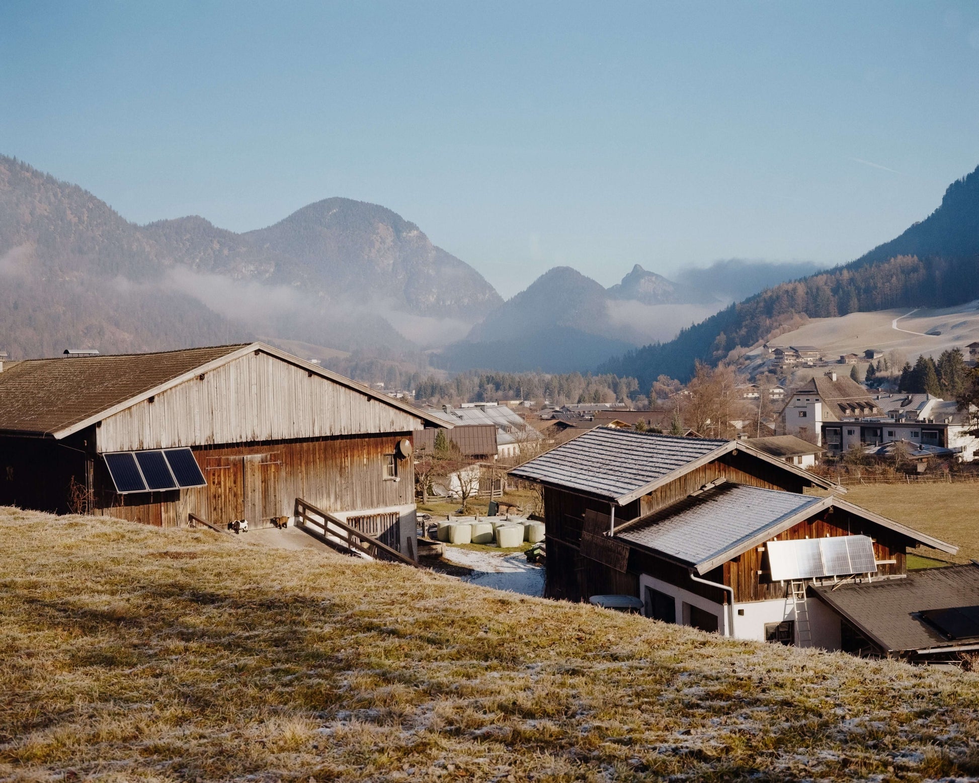 Scenic view of traditional wooden houses in a mountainous landscape with clear blue skies, shot with Kodak Eastman Gold 200 Color Negative Film