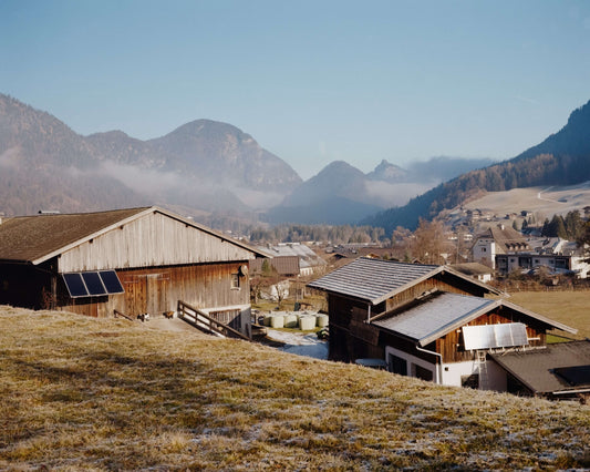 Scenic view of traditional wooden houses in a mountainous landscape with clear blue skies, shot with Kodak Eastman Gold 200 Color Negative Film