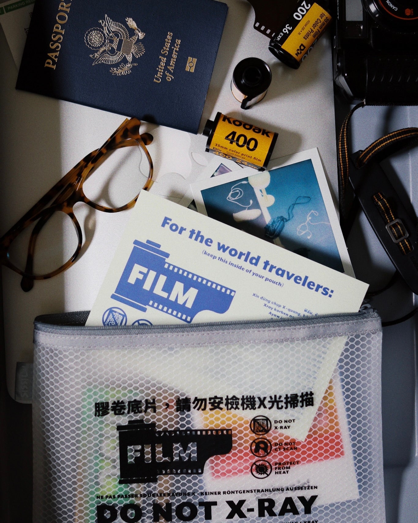 SissiLu "DO NOT X‑RAY" Film Pouch alongside passport, film rolls, and glasses for travel safety.