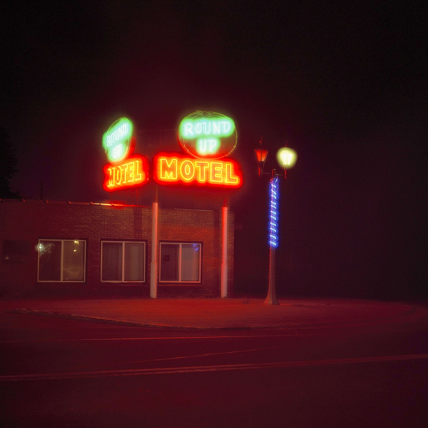 Round Up Motel neon sign at night, vibrant colors illuminating the surrounding area.