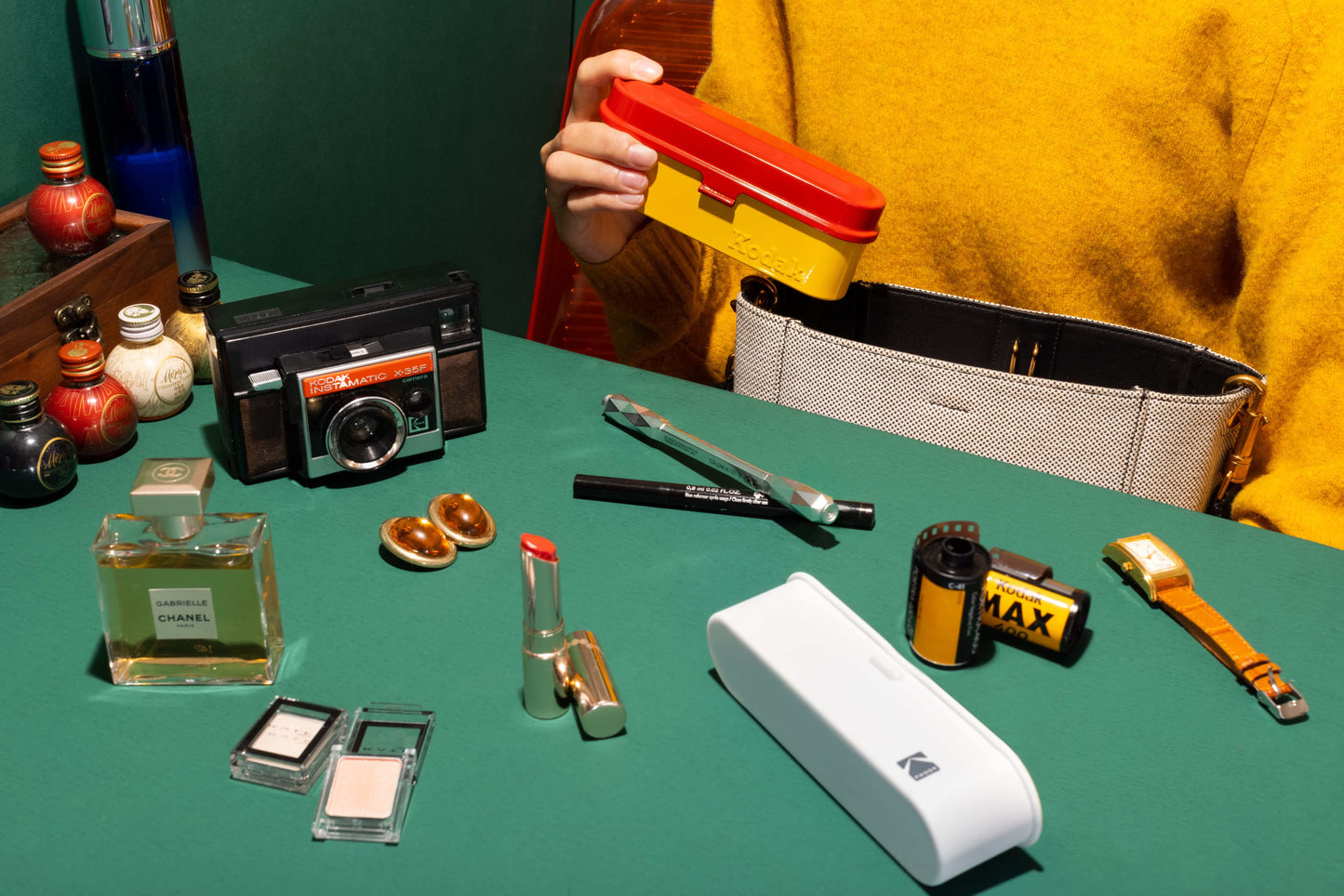 Kodak 135 Film Case (White) displayed among vintage camera and cosmetics