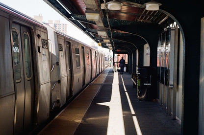 Subway station platform with passing train and a lone figure, captured on Kodak Kodacolor 100 Color Negative Film (35mm, 36 Exposures).