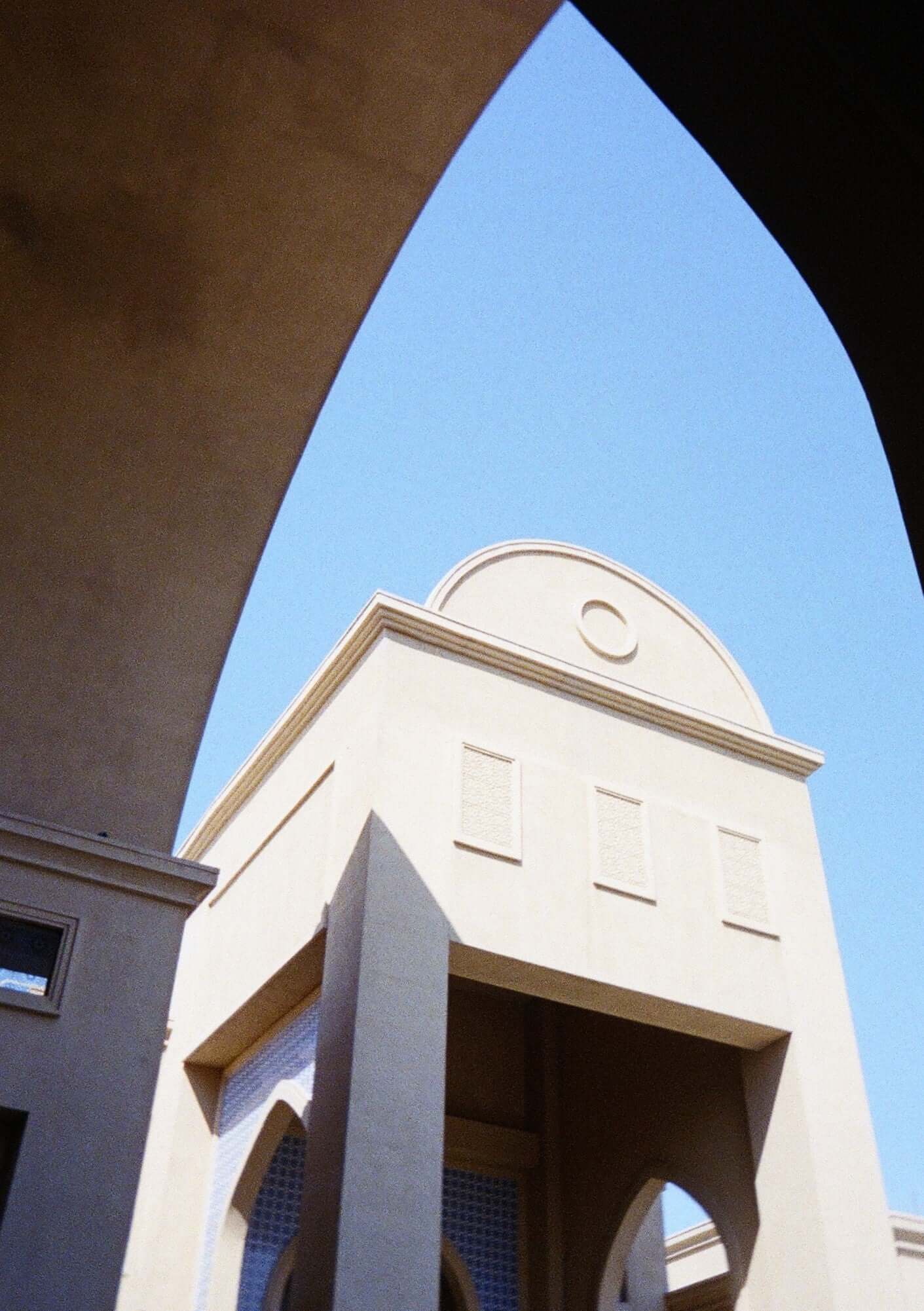 Architectural shot of a building against a clear blue sky captured with Kodak Ektar H35N Half Frame Film Camera (BT21 Edition).