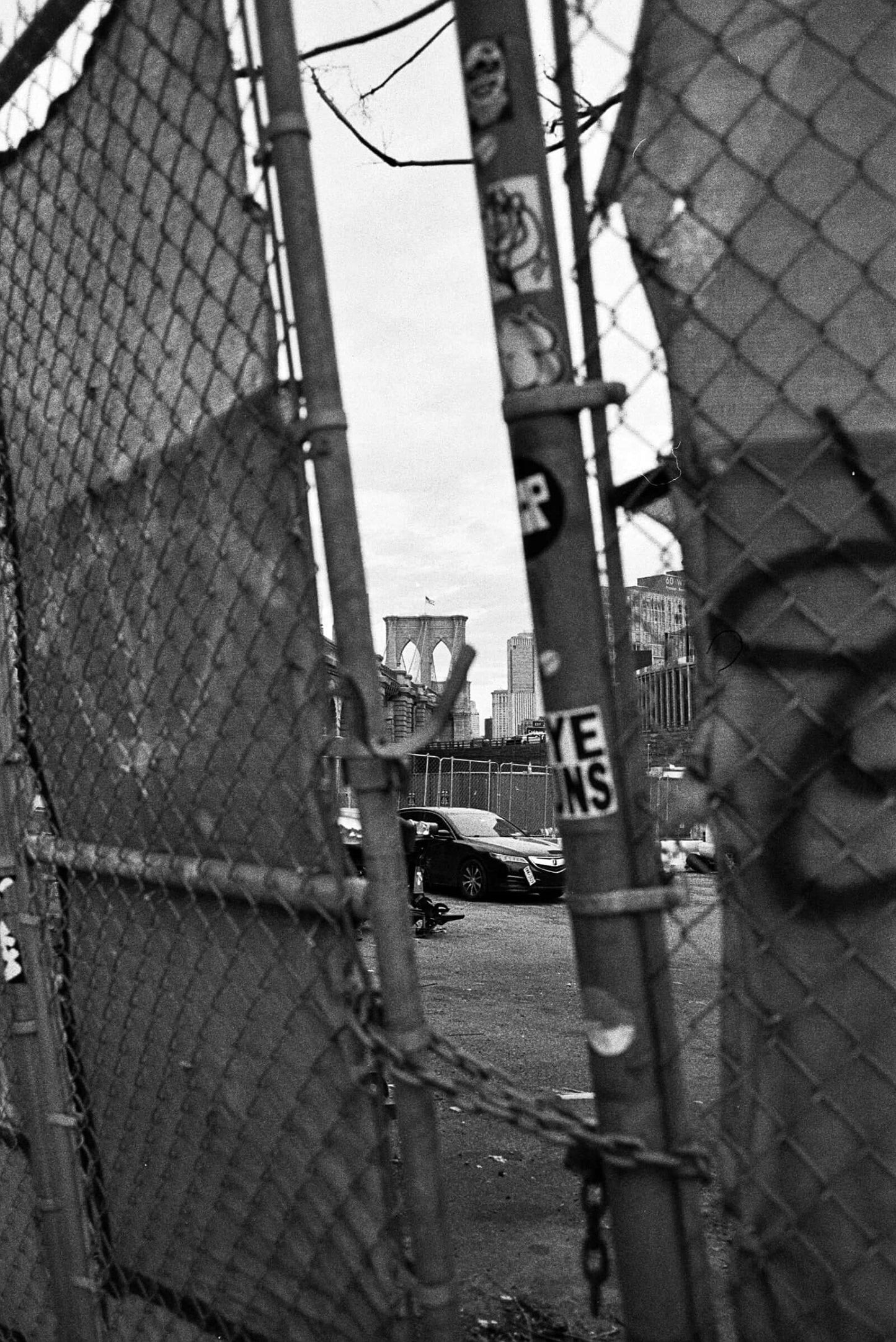View through a chain-link fence of Brooklyn Bridge captured with Kodak Tri-X 400 Single-Use Camera (27 Exposures).