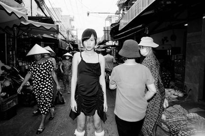 Model standing in a bustling market surrounded by shoppers, captured in striking black and white shot with Mr Negative Cash Only 100