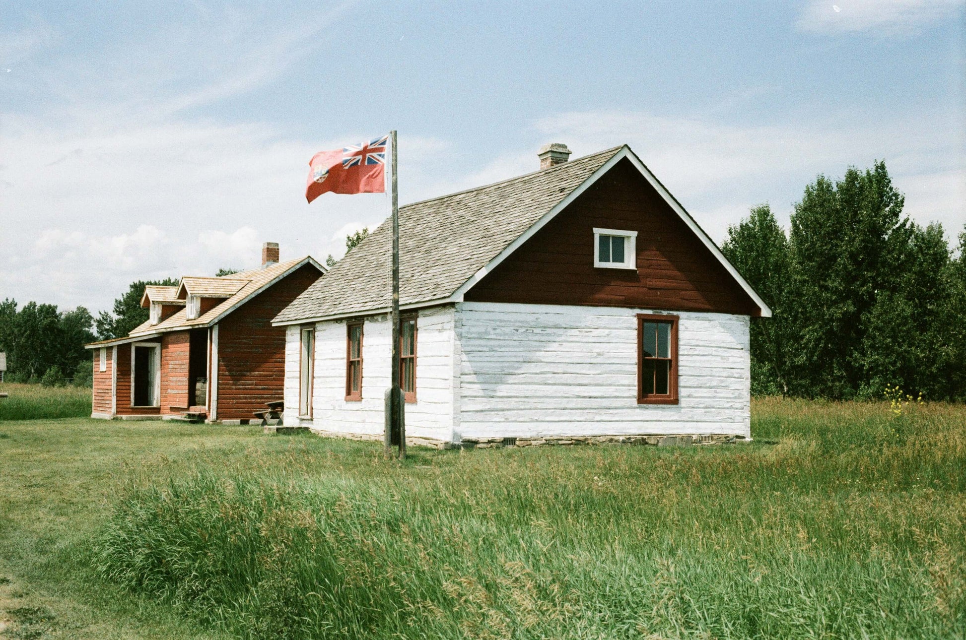 Street Candy Tasty 200 Color Negative Film displayed with historic wooden houses and a flag in a green field.