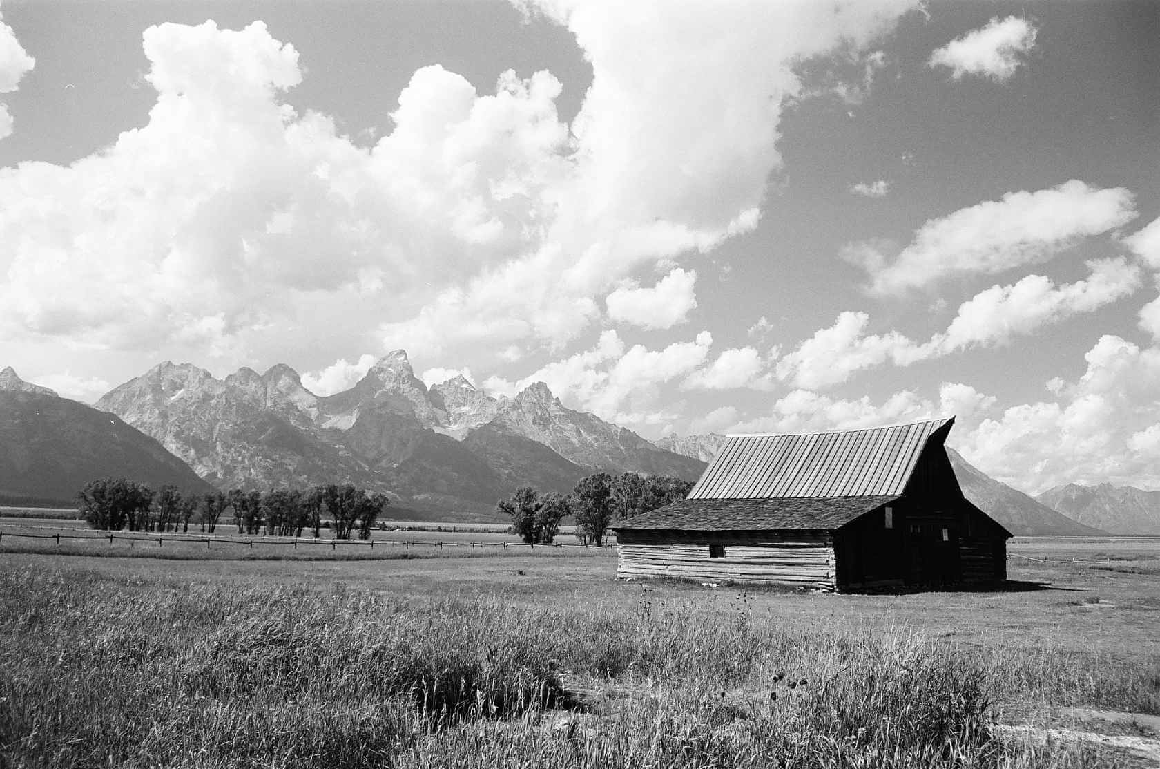 Kodak Ektapan 100 Black and White Negative Film image of a rustic barn with mountains in the background.