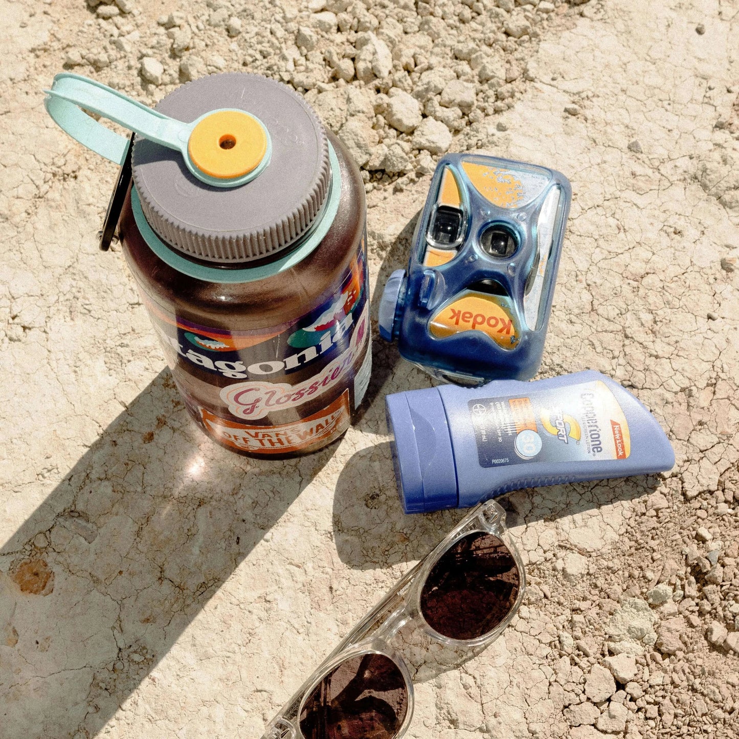 kodak water proof disposable camera with water bottle, sunscreen, and sunglasses